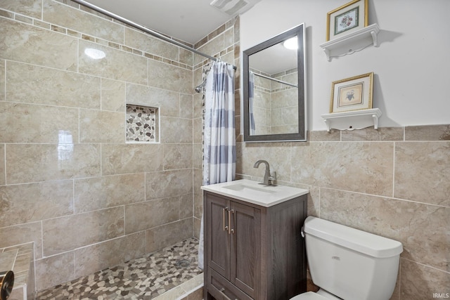 bathroom with a shower with curtain, vanity, tile walls, and toilet