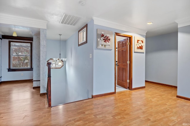 interior space with light hardwood / wood-style floors, crown molding, and a chandelier