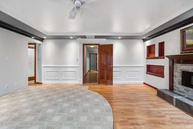 unfurnished living room with a fireplace, light wood-type flooring, and ceiling fan