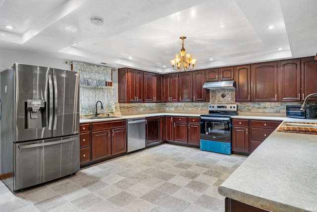 kitchen with a raised ceiling, sink, and stainless steel appliances