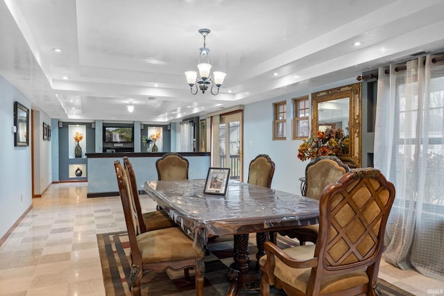 dining area featuring a tray ceiling and an inviting chandelier