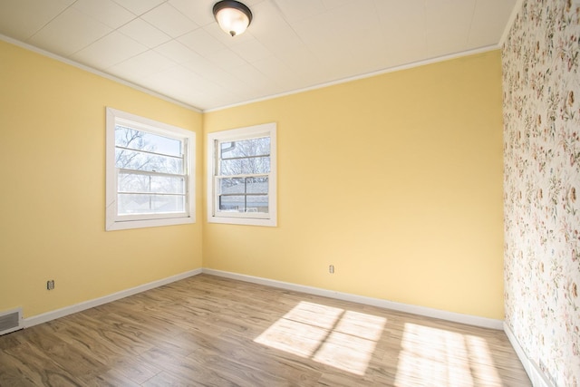 unfurnished room featuring light hardwood / wood-style floors and crown molding