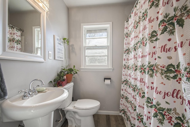 bathroom with hardwood / wood-style flooring, toilet, curtained shower, and sink