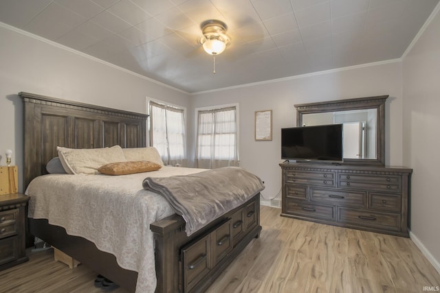 bedroom featuring ceiling fan, light wood-type flooring, and ornamental molding