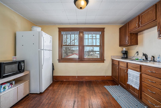 kitchen with white refrigerator, dark hardwood / wood-style flooring, and sink