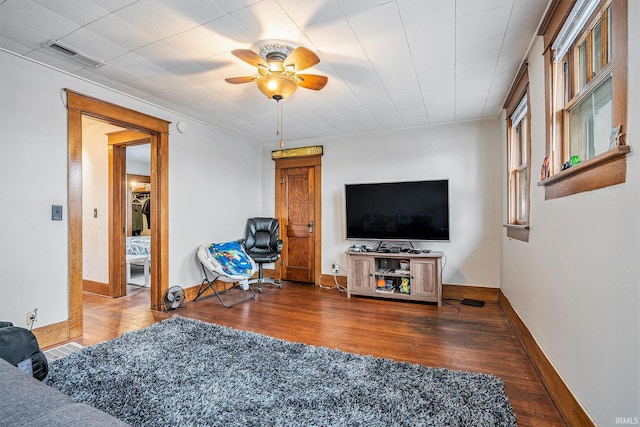 living room with ceiling fan and dark hardwood / wood-style flooring