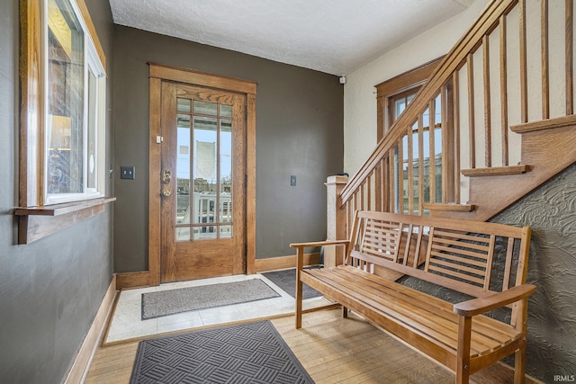 entryway with a textured ceiling and hardwood / wood-style flooring