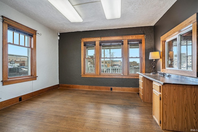 kitchen with a textured ceiling and dark wood-type flooring