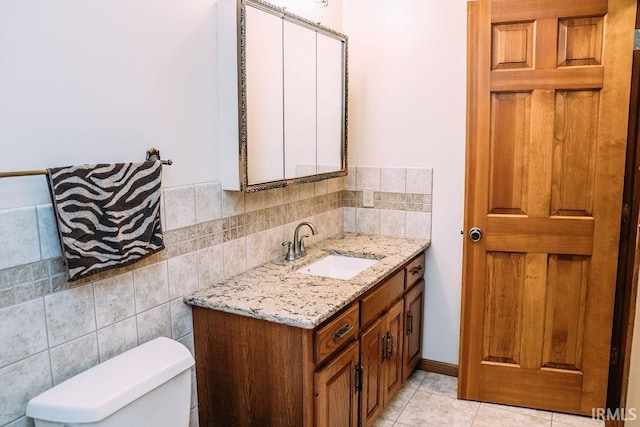 bathroom featuring tile patterned flooring, vanity, toilet, and backsplash