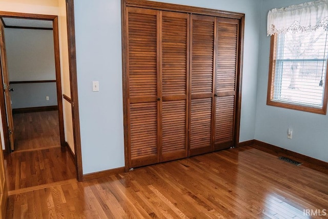 unfurnished bedroom featuring hardwood / wood-style flooring and a closet