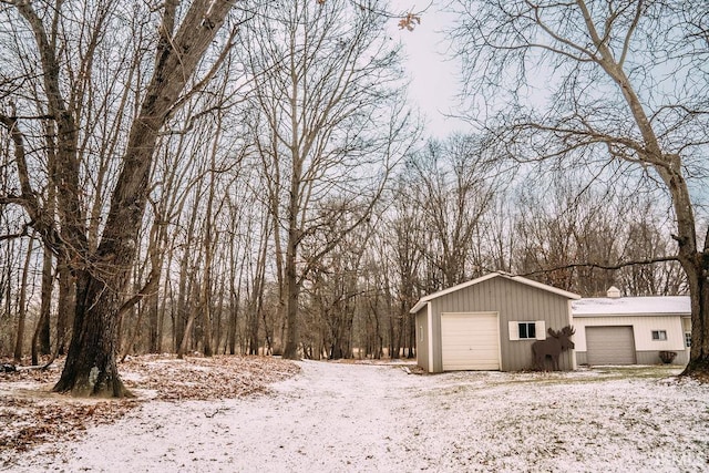 yard layered in snow featuring a garage