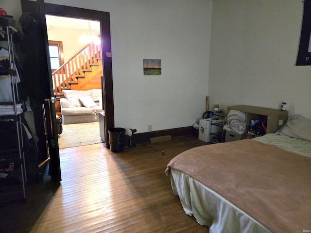 bedroom with a chandelier and hardwood / wood-style floors