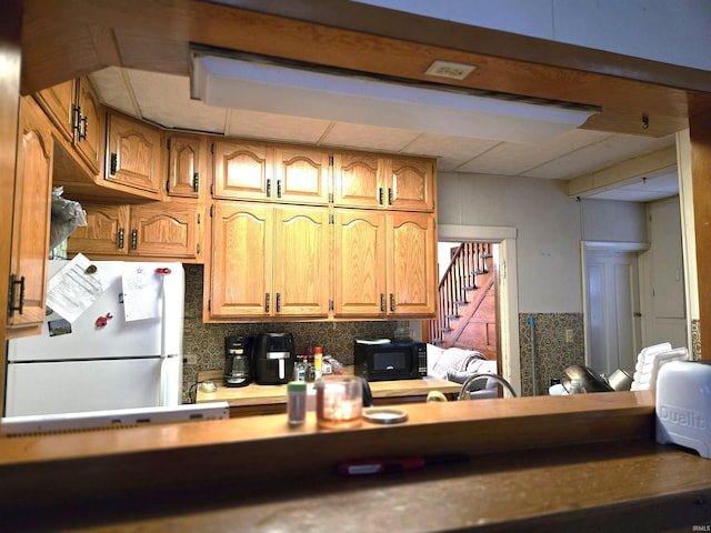 kitchen with decorative backsplash and white fridge