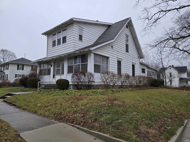 view of front of property featuring a sunroom and a front yard