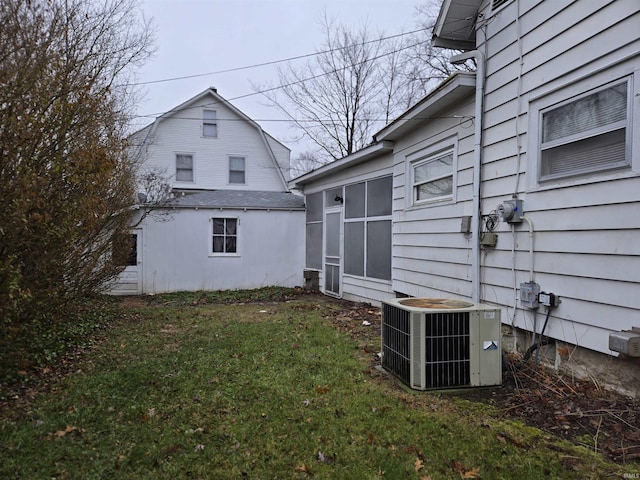 view of side of home featuring a lawn and cooling unit