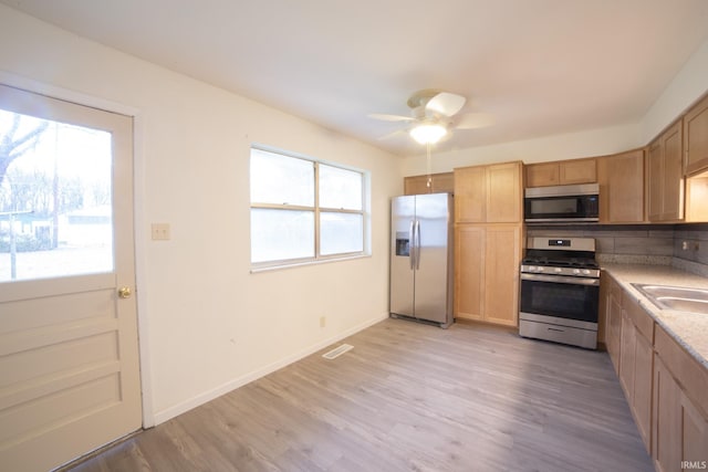 kitchen featuring appliances with stainless steel finishes, light wood-type flooring, ceiling fan, and sink