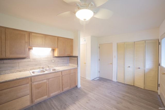 kitchen with light brown cabinets, sink, light hardwood / wood-style flooring, ceiling fan, and tasteful backsplash