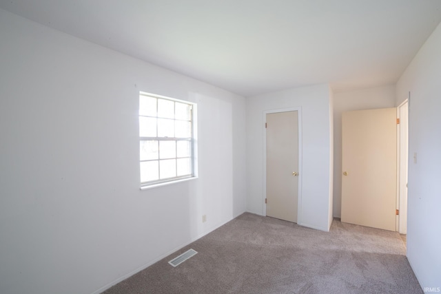 unfurnished bedroom featuring light carpet and a closet