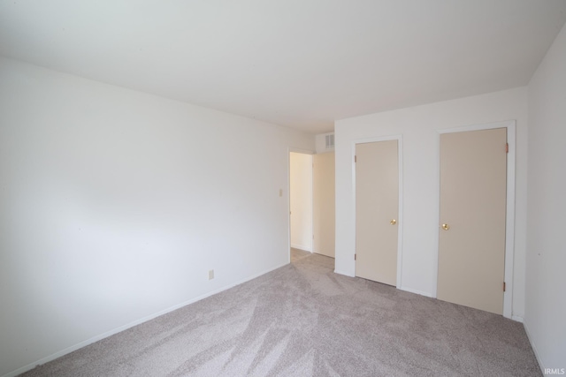 unfurnished bedroom with a closet and light colored carpet