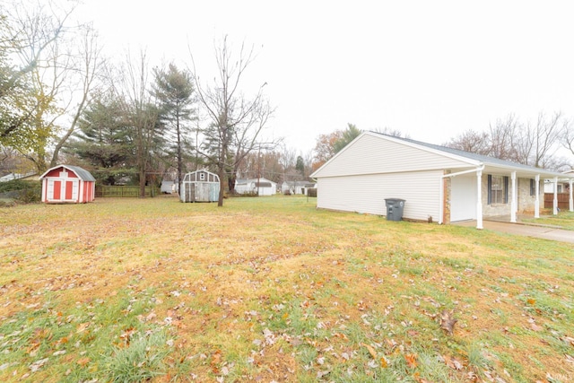 view of yard featuring a carport and a storage unit