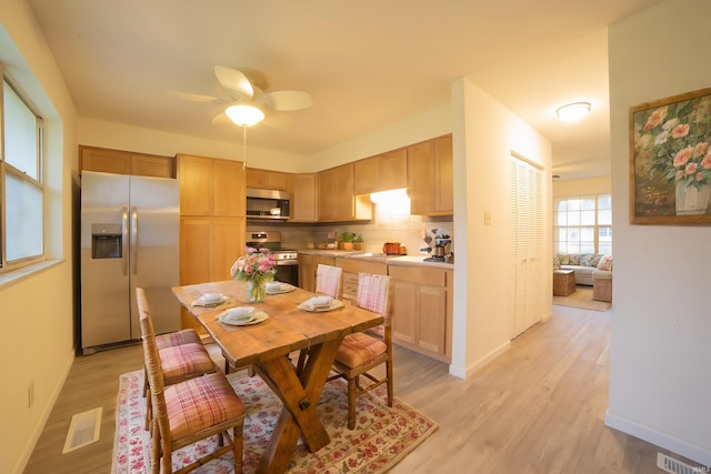 dining room with ceiling fan and light hardwood / wood-style floors