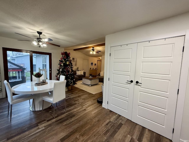 dining space with vaulted ceiling with beams, ceiling fan, dark hardwood / wood-style flooring, and a textured ceiling