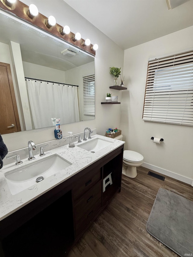 bathroom with hardwood / wood-style flooring, vanity, and toilet