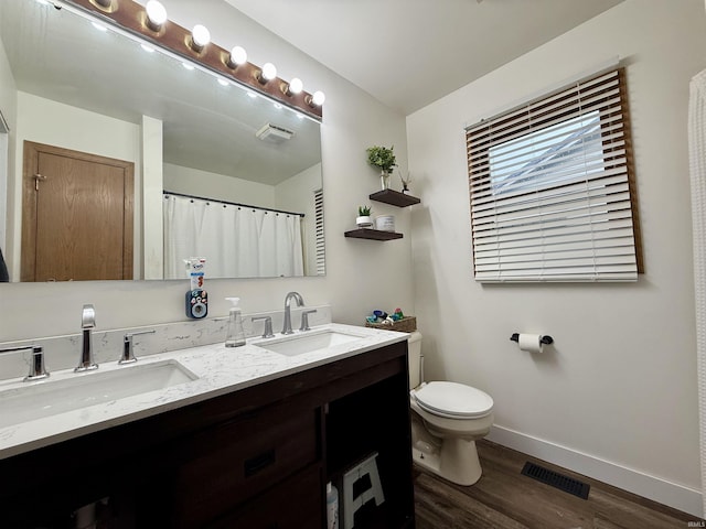 bathroom with hardwood / wood-style floors, vanity, and toilet