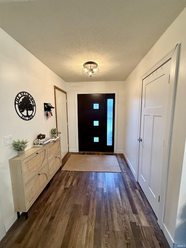 doorway to outside with dark hardwood / wood-style flooring and a textured ceiling