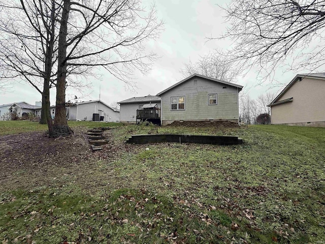 back of property with a yard and a wooden deck