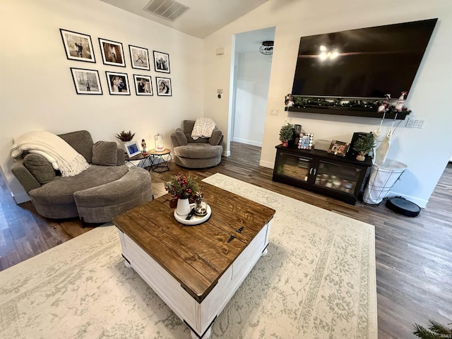 living room featuring vaulted ceiling and dark hardwood / wood-style floors