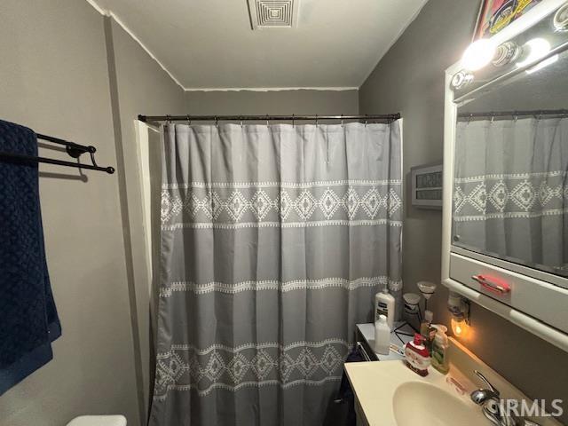 bathroom with a shower with shower curtain, vanity, and toilet