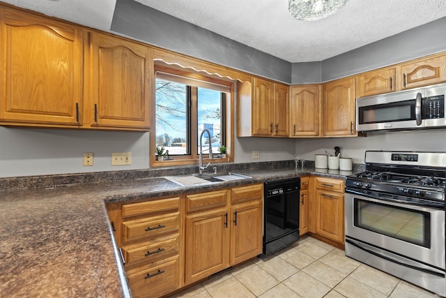 kitchen featuring sink, light tile patterned floors, a textured ceiling, and appliances with stainless steel finishes