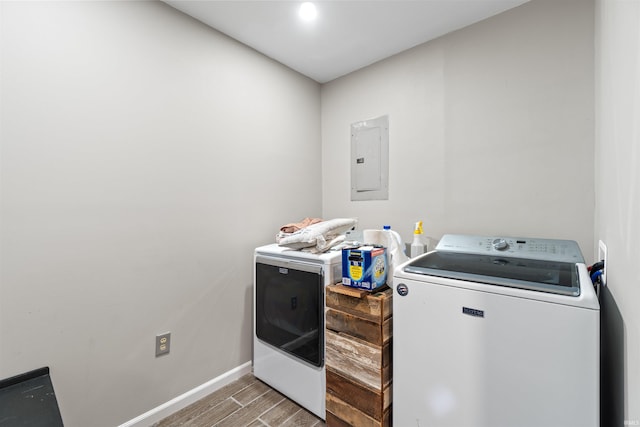 laundry room with wood-type flooring, electric panel, and independent washer and dryer