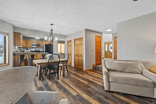 dining room featuring a textured ceiling, an inviting chandelier, and dark wood-type flooring