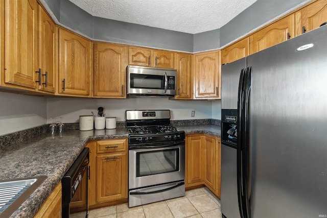 kitchen with black appliances, light tile patterned flooring, sink, and a textured ceiling