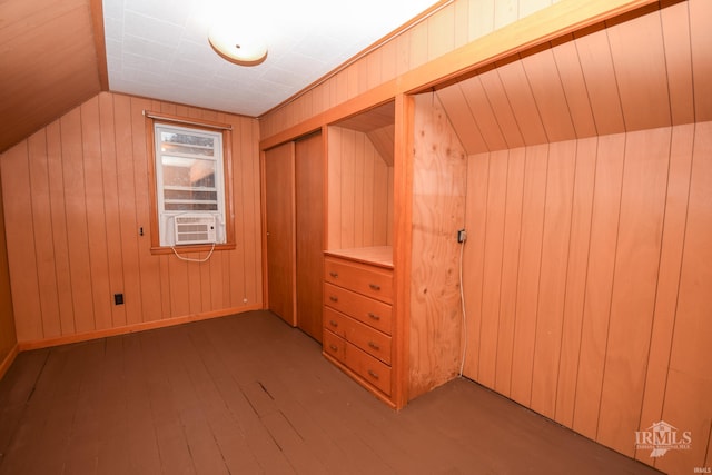 additional living space featuring wooden walls, cooling unit, vaulted ceiling, and hardwood / wood-style flooring