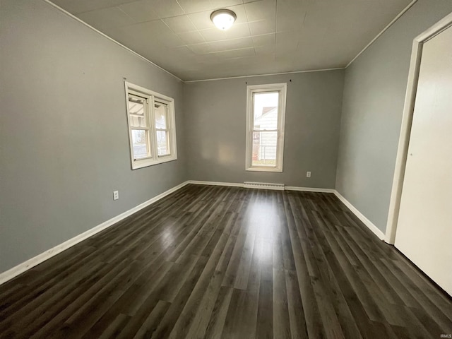 spare room featuring dark hardwood / wood-style flooring and ornamental molding