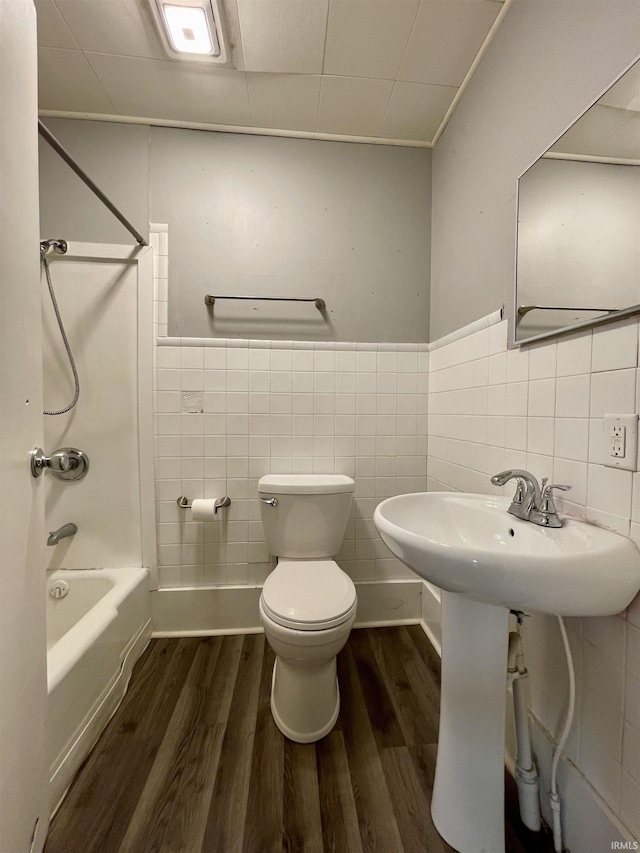 bathroom featuring toilet, tub / shower combination, tile walls, and hardwood / wood-style flooring