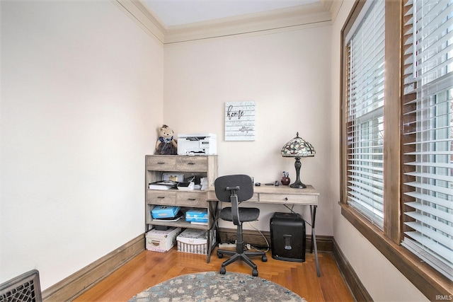 home office featuring plenty of natural light, ornamental molding, and hardwood / wood-style flooring