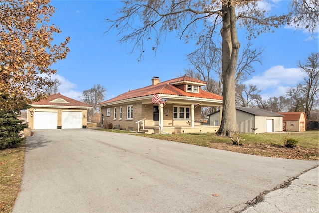 view of front of property with a porch, a garage, and an outdoor structure