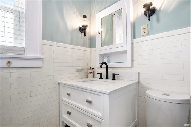 bathroom with vanity and tile walls