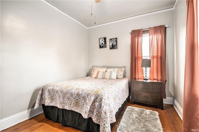 bedroom with crown molding, ceiling fan, and dark hardwood / wood-style floors