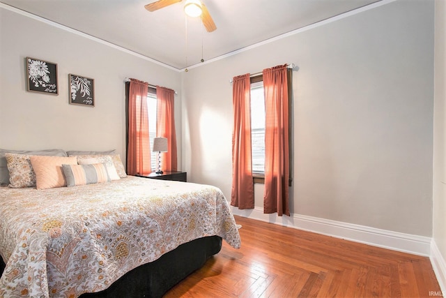 bedroom featuring ceiling fan, parquet flooring, and multiple windows