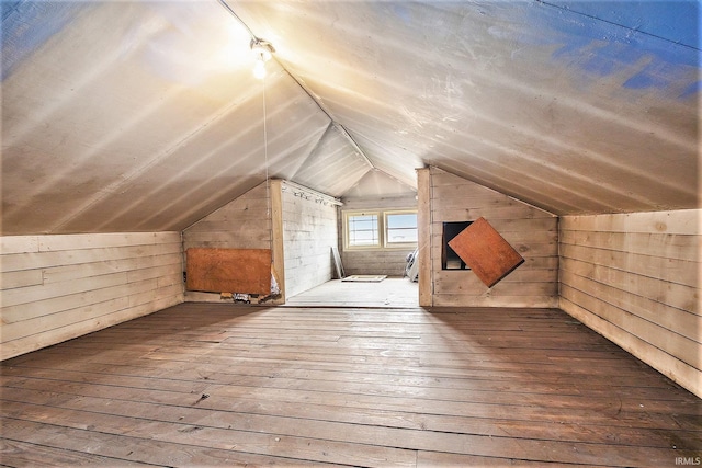 bonus room with wooden walls, hardwood / wood-style floors, and lofted ceiling