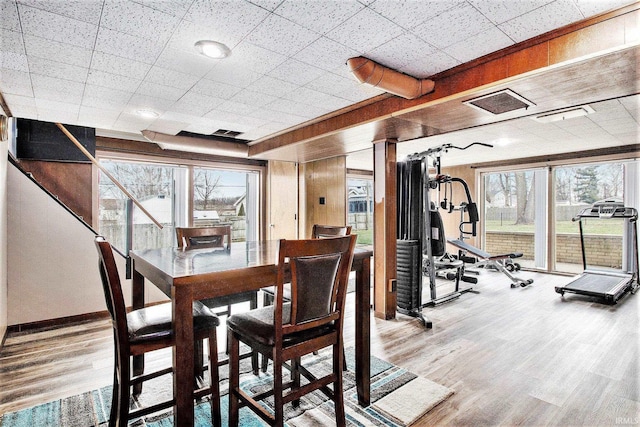 dining space with a paneled ceiling and hardwood / wood-style flooring