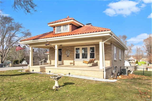 mediterranean / spanish house with a front lawn and cooling unit