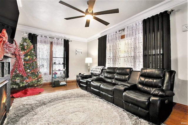 cinema room with wood-type flooring, ceiling fan, and ornamental molding