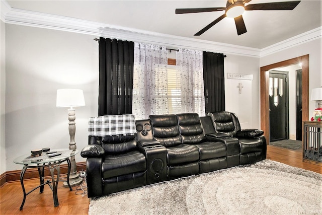 home theater featuring hardwood / wood-style floors, ceiling fan, and ornamental molding