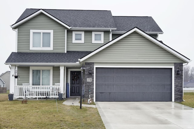 view of front facade featuring a porch, a front yard, and a garage